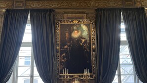 Une pièce dotée d’un grand miroir décoratif, de rideaux somptueux et d’un sol recouvert de moquette.