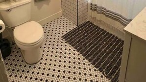 Une petite salle de bain comprenant des toilettes, un lavabo et un espace douche.