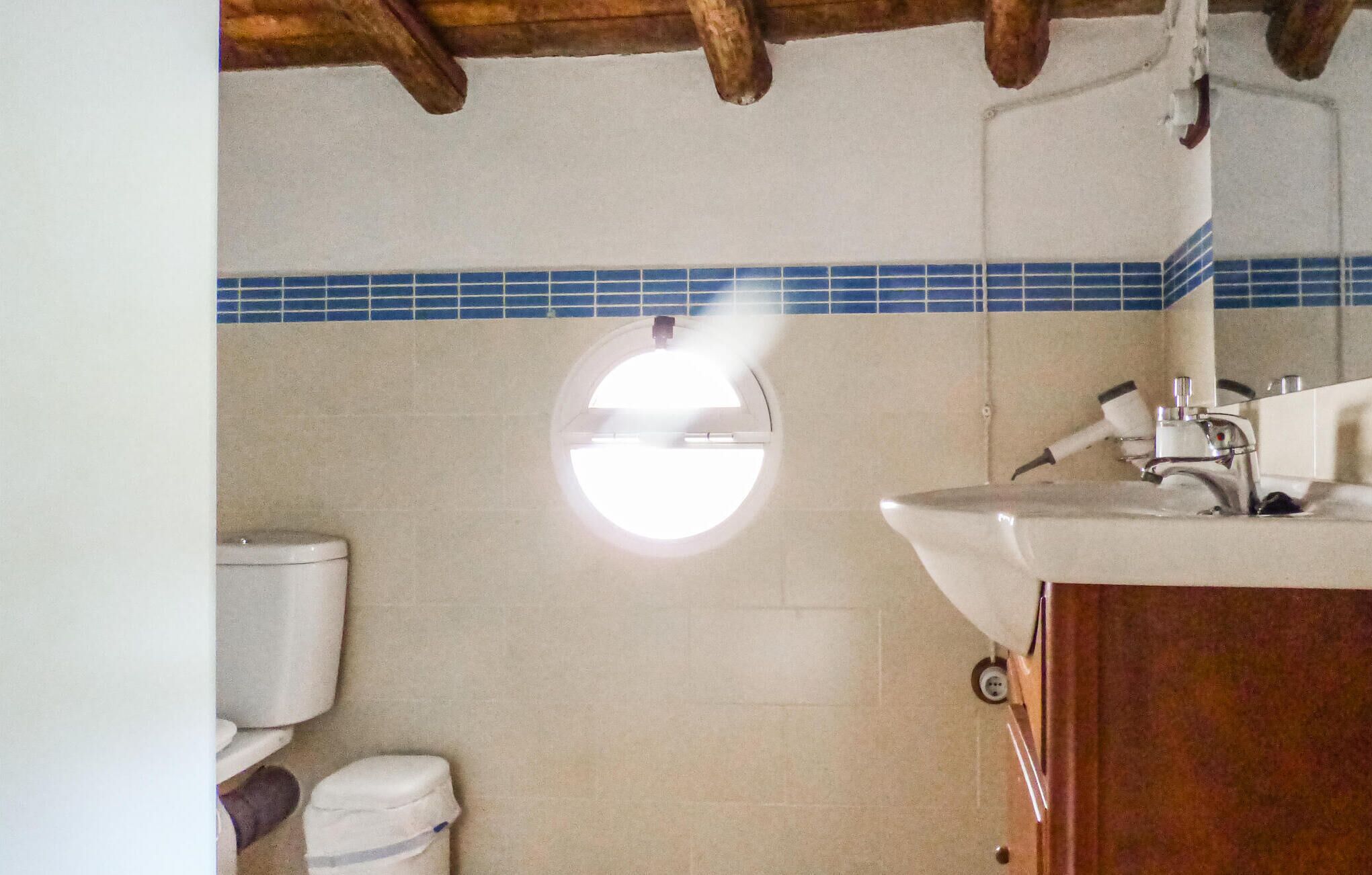 Un baño con inodoro, lavabo y espejo.