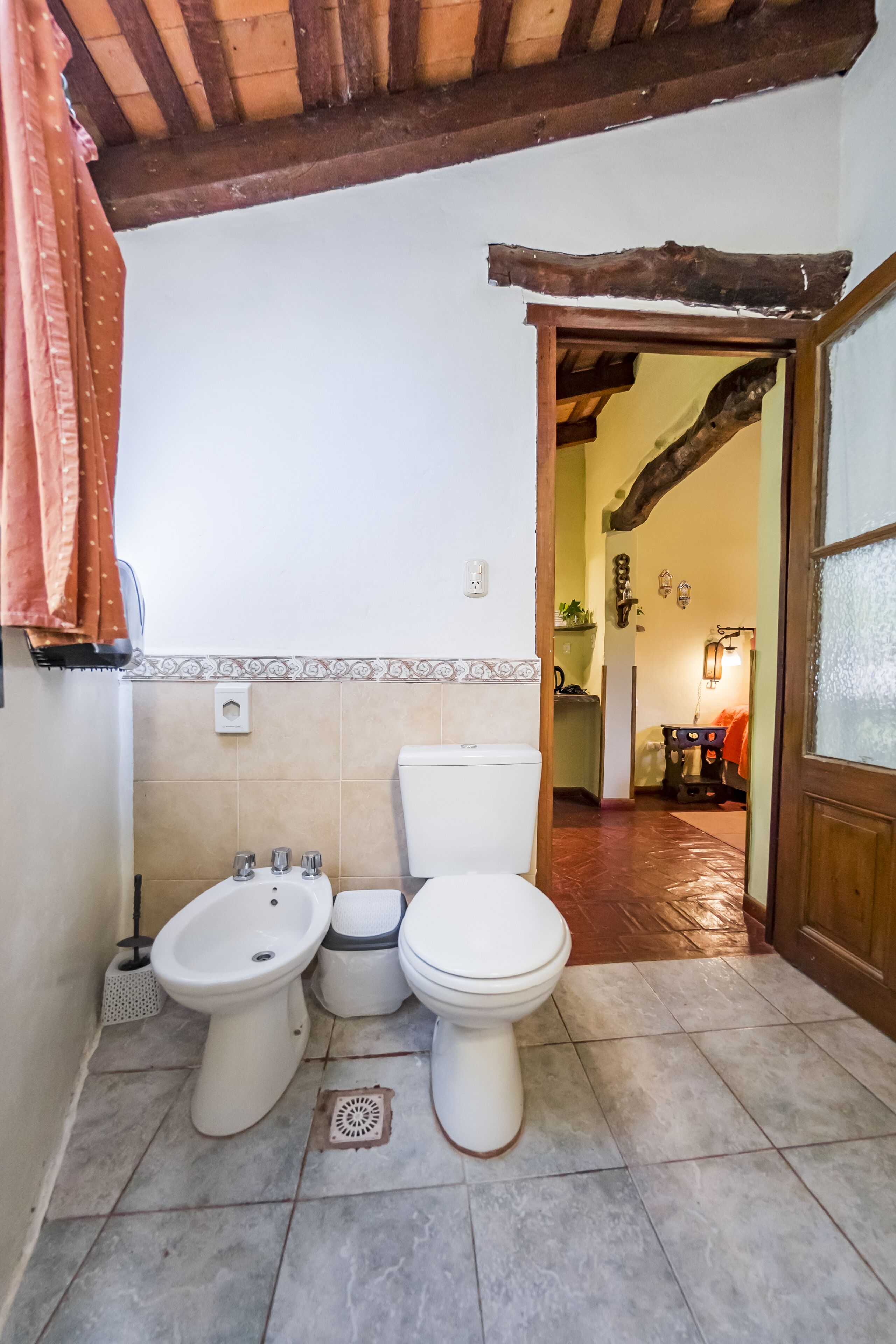 A bathroom with two toilets, a bidet, and a shower area.