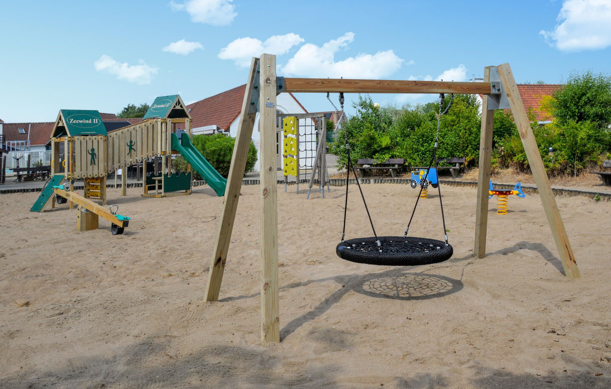 Ein Spielplatz mit Schaukel und Rutsche.