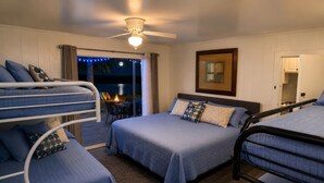 A bedroom with bunk beds, a ceiling fan, and a view of the outdoors.