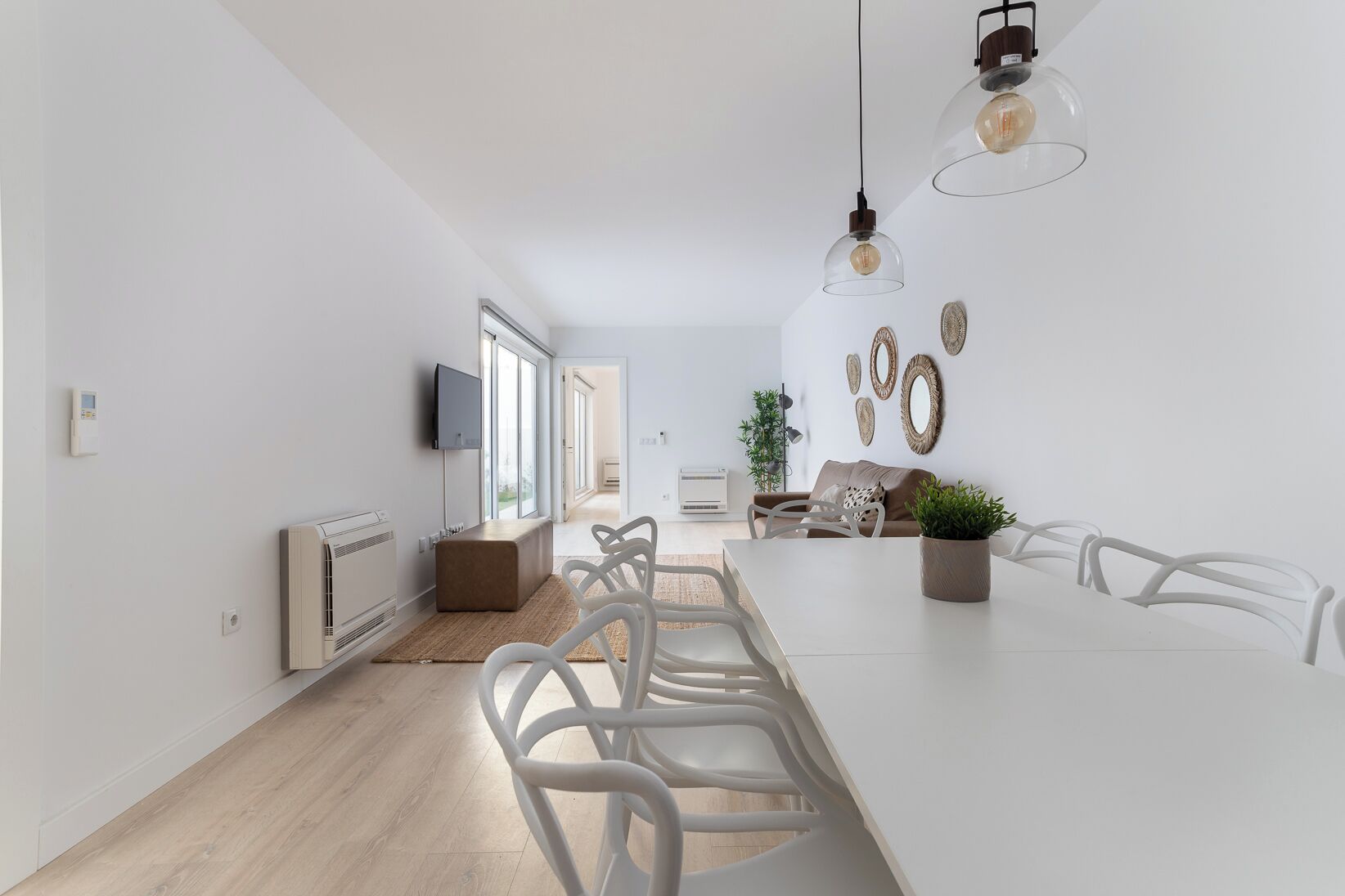 A modern kitchen with a central island, white cabinetry, and pendant lighting.