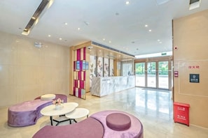 A hotel lobby with seating areas, a reception desk, and a large glass door entrance. - Lavande Hotel (Guangzhou Jiahe Wanggang Metro Station) (Guangzhou)