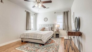 A bedroom with a bed, a desk, a chair, a ceiling fan, and a rug. - 15% Summer Discount~ Entire Home ~ Full Kitchen ~ Large Fenced Backyard (Oklahoma City)