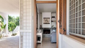 Una puerta abierta que da a una sala de estar con chimenea, un sofá y una mesa de centro.