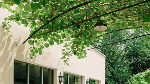 A building with large windows and a gravel pathway leading to it. - The Greenhouse Luxury Villa Lake Como (Como)