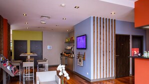 Un intérieur moderne comprenant un coin repas, une cuisine et un téléviseur fixé au mur.