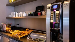 Un espace café en libre-service équipé d’une machine à expresso KREA Necta, d’un assortiment de viennoiseries et d’un choix de boissons.