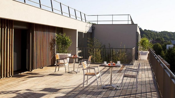 A rooftop terrace with outdoor seating, a railing, and a view of the surrounding area. - À 10 min du métro | Terrasse + Vue panoramique (Lyon)
