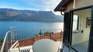 Een balkon met uitzicht op een meer en bergen.