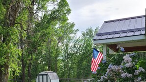 A well-maintained lawn, a small shed, and a house with a porch.