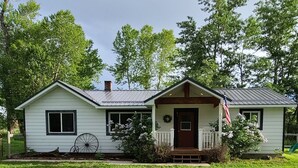 A single-story house with a porch, a front door, and a small garage.
