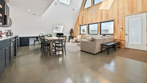 A modern loft-style living space with a kitchen, dining area, and seating area.