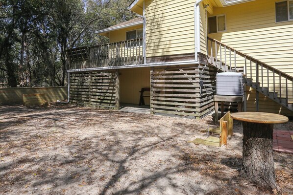 A yellow building with a wooden deck and a covered outdoor area.