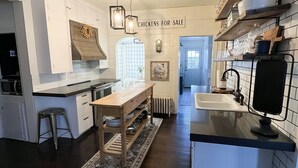 A modern kitchen with white cabinetry, a wooden island, and a 'Chickens for Sale' sign. - Gorgeous downtown beauty! 2min walk to local restaurant's/Main Street Montrose (Montrose)