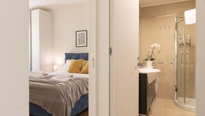 Ein modernes Schlafzimmer mit einem Bett, einem Nachttisch und einem gerahmten Bild an der Wand.