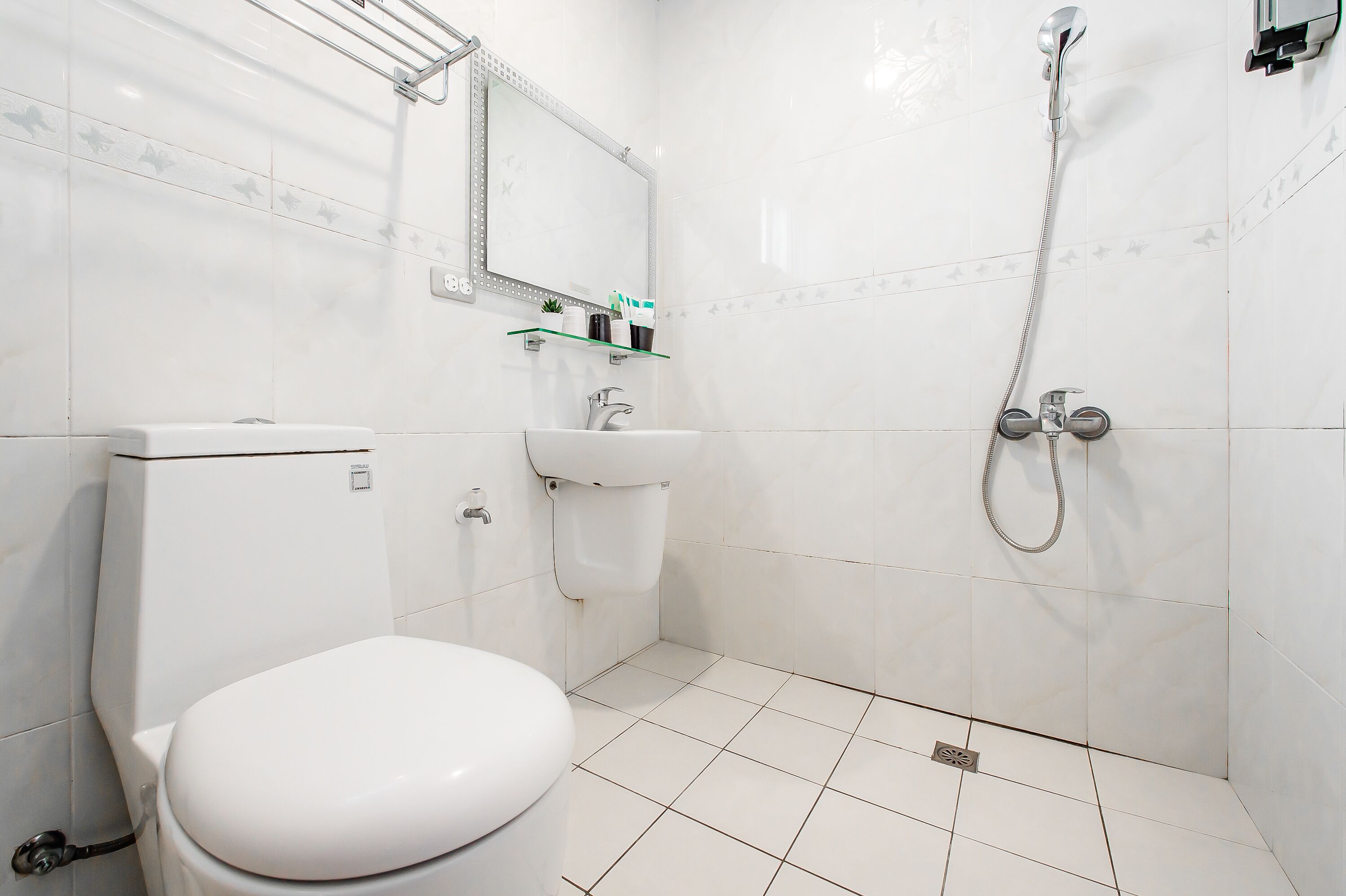 A bathroom with a toilet, sink, and shower.