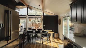 Una cocina moderna con comedor, ventanas amplias y vistas al exterior.