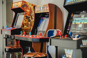 Una hilera de máquinas de videojuegos con títulos y puntajes visibles.