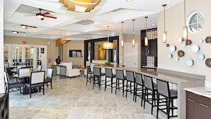 A modern hotel lobby with a bar area, seating, and a TV. - Luxury 13 Bedroom Villa in Orlando , Orlando Villa 6269 (Orlando)