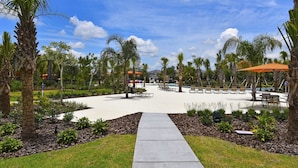 A resort pool area with lounge chairs, palm trees, and a clear sky. - Luxury 13 Bedroom Villa in Orlando , Orlando Villa 6269 (Orlando)