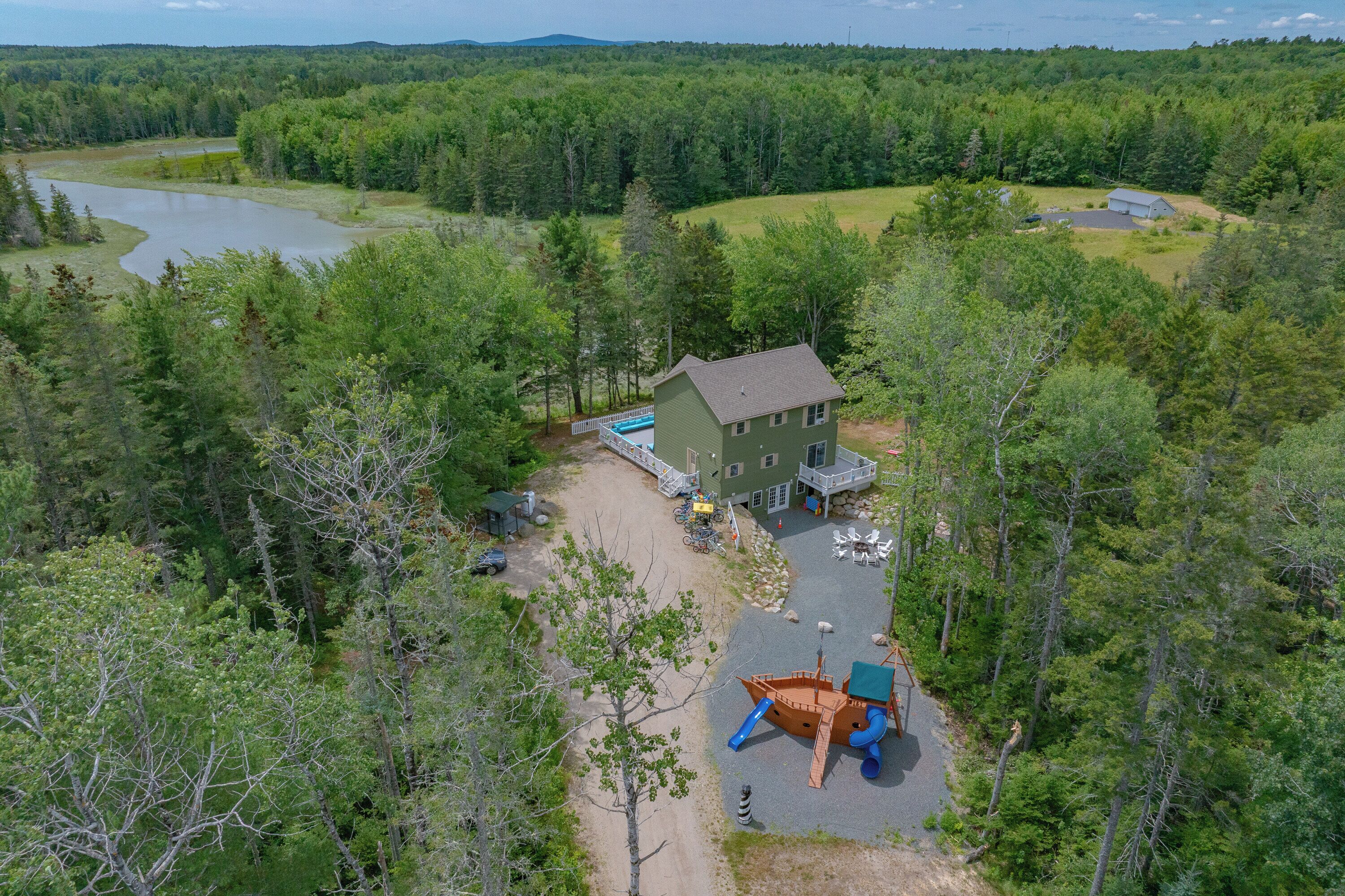 Un chalet doté d’un quai, d’un bateau et d’une aire de jeux.