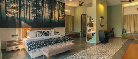 A modern bedroom with a large bed, a seating area, and a dining table.