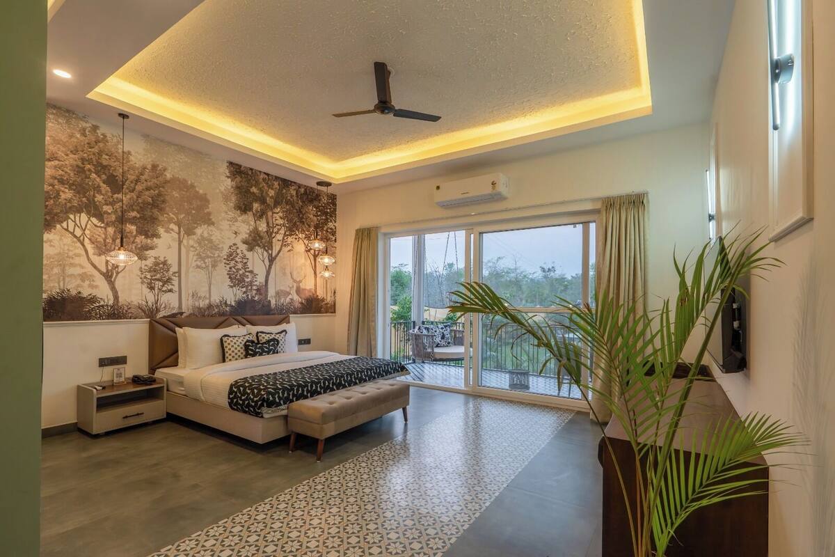A modern bedroom with a large bed, a ceiling fan, a mural, and a balcony with a view.