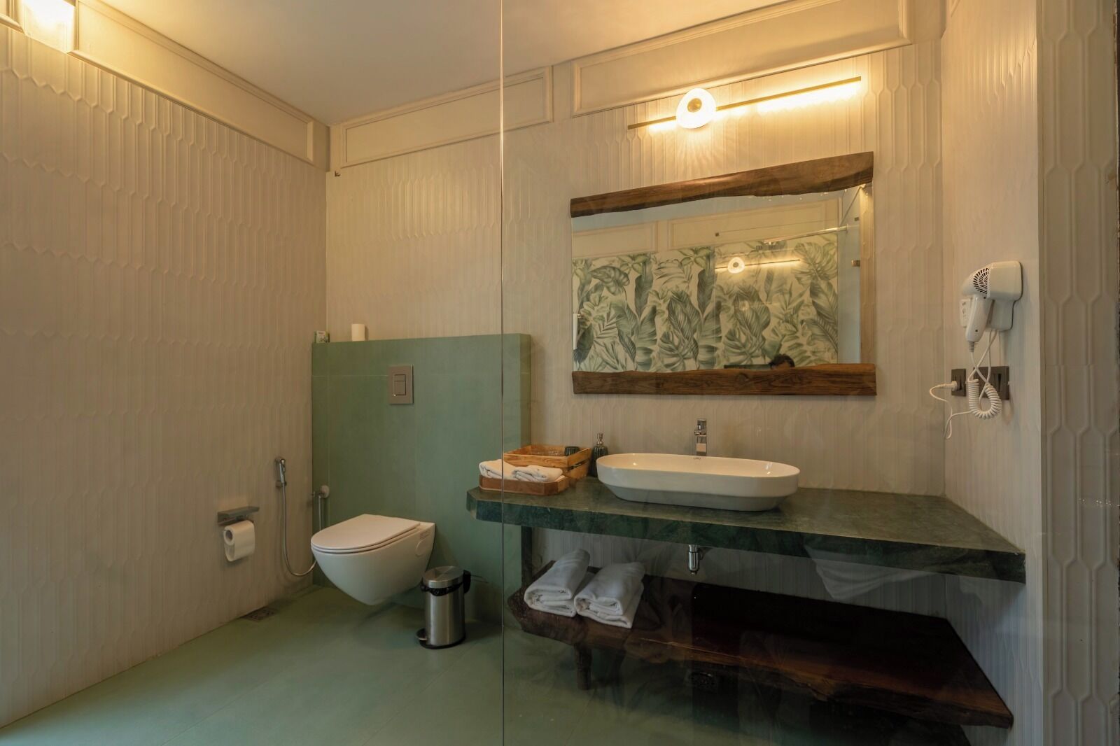 A bathroom with a toilet, a sink, and a shower area.