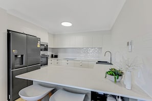 Enjoy cooking in this well-equipped kitchen with a central island, appliances, and a convenient water dispenser.