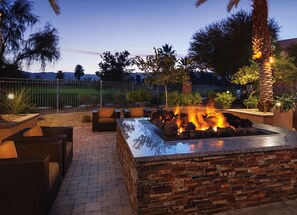 Relax and socialize by the fire pit, surrounded by a patio and comfortable seating.