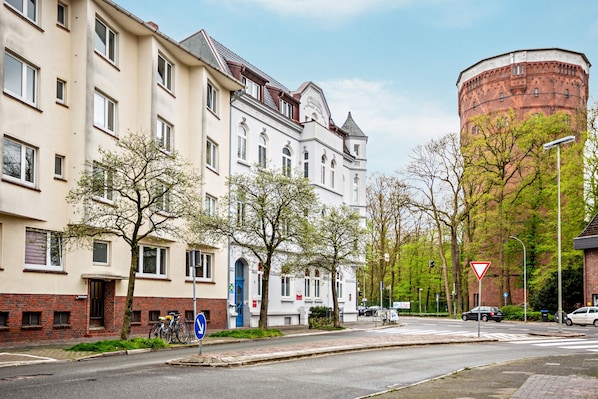 A street with buildings, a round tower, and a blue door.