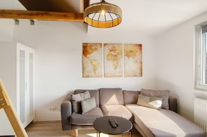 A modern living room with a sectional sofa, a small round table, and a world map artwork on the wall.