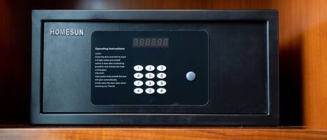 A black security safe with a digital keypad and operating instructions.