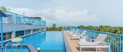 Una piscina al aire libre, tumbonas