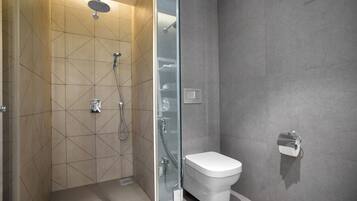Ein modernes Badezimmer mit einer gläsernen Duschkabine, einer weißen Toilette und einem Handtuchhalter.