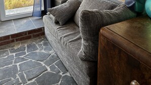 A cozy room with a stone floor, a window with curtains, and a wooden bench. - Old miller's house by the windmill (Wittingen)