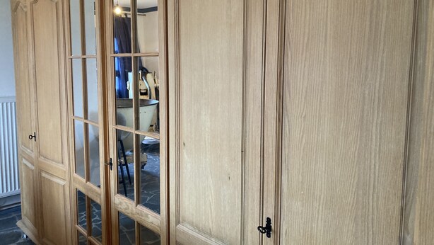 A large wooden cabinet with glass doors and a keyhole. - Old miller's house by the windmill (Wittingen)