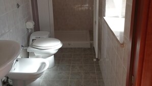 Une petite salle de bain comprenant des toilettes, un bidet et un lavabo.