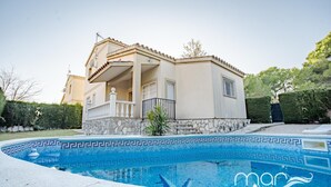 Une maison à deux étages avec une piscine à l’avant.