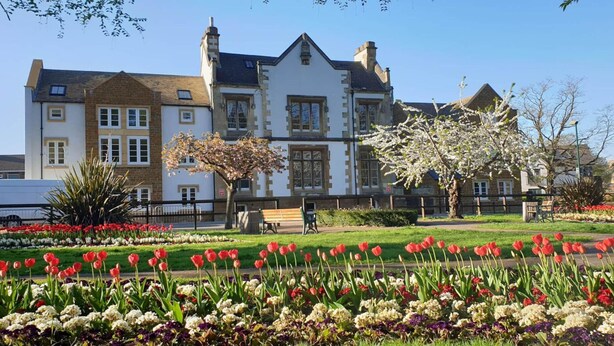 A large building with multiple windows and a garden with red tulips and white flowers in front. - Inviting 1-bed Apartment in Banbury (Banbury)