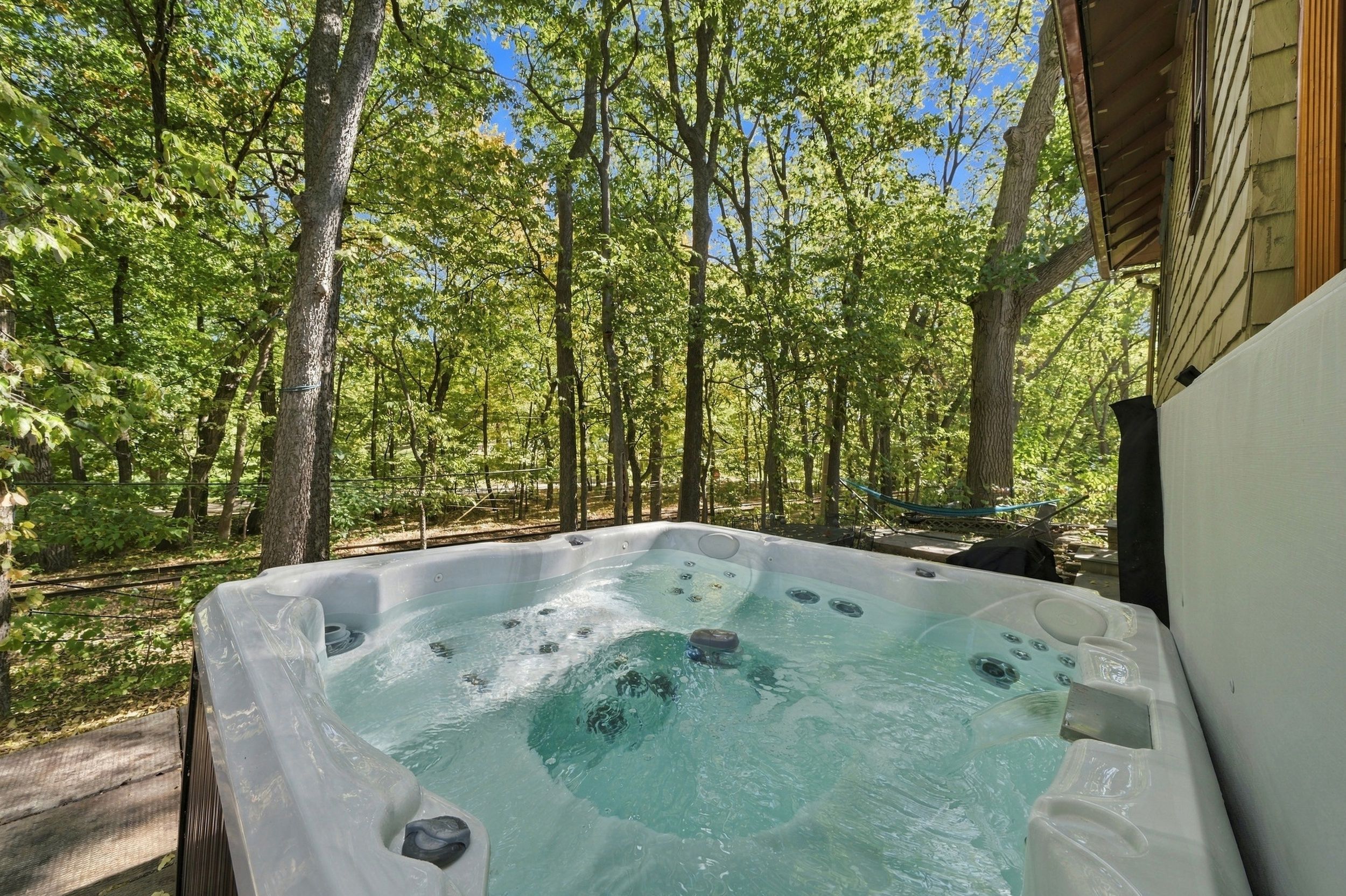 A hot tub in a wooded area with trees surrounding it.
