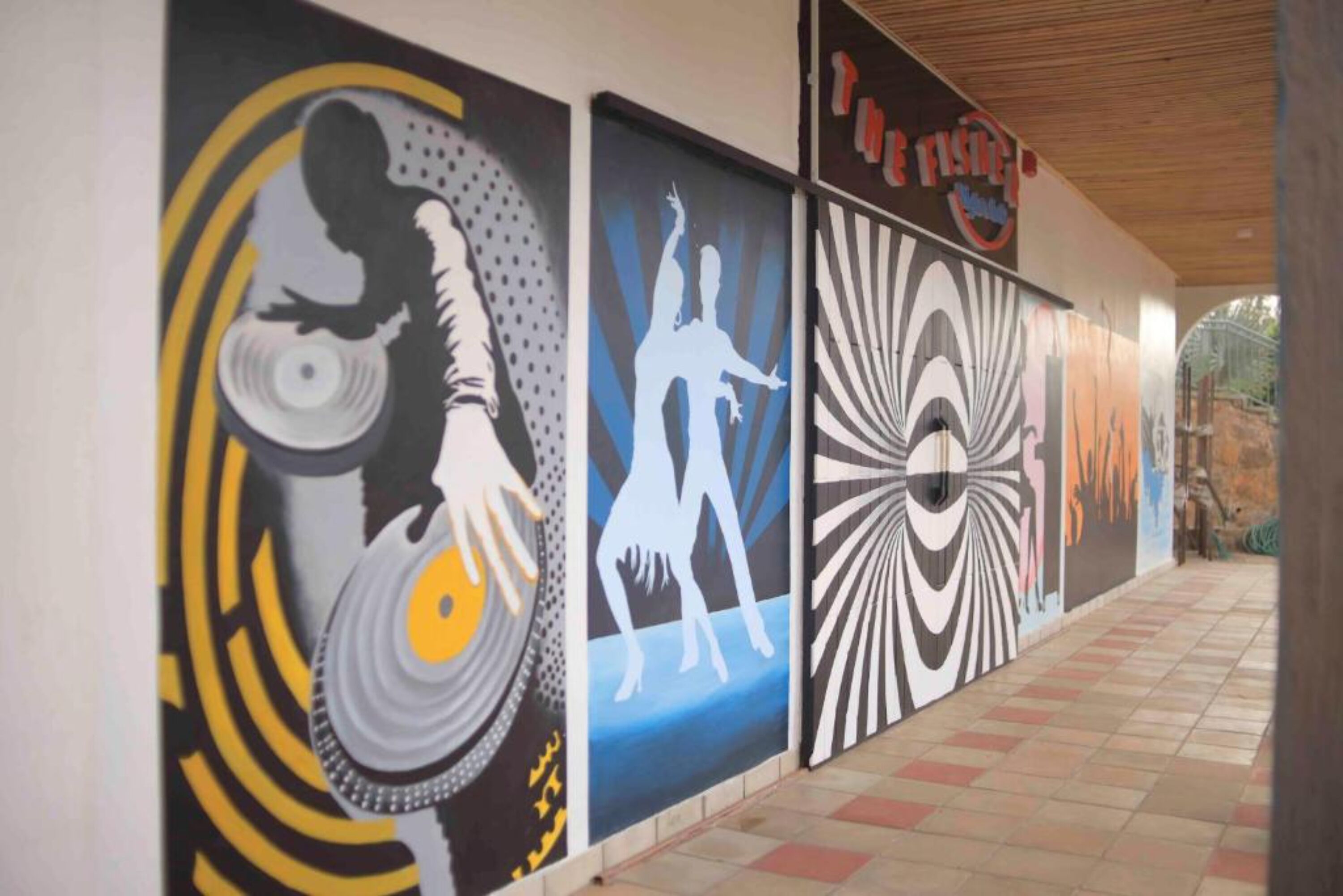 Un pasillo con arte abstracto en la pared y un letrero que dice 'The Fish'.