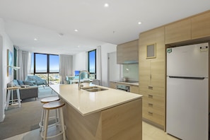 Enjoy a spacious kitchen with a central island, sink, and refrigerator, complemented by comfortable seating and a scenic view.