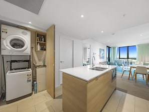 Enjoy a spacious kitchen with a washing machine and compact refrigerator, complemented by a large island with a sink.