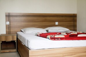 A single bed with a wooden headboard, white bedding, and a red blanket. - Hotel Esplanade (Cox's Bazar)