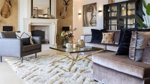Un salon moderne avec une cheminée, une table basse en verre et un canapé.