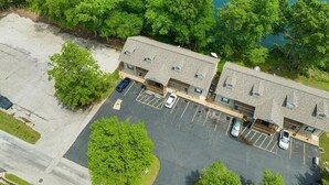 An aerial view of a motel with a parking lot and a river in the background. - Lakeside, fishing, Cozy 2/2 - 5 minutes from Branson attractions and Table Rock (Branson)