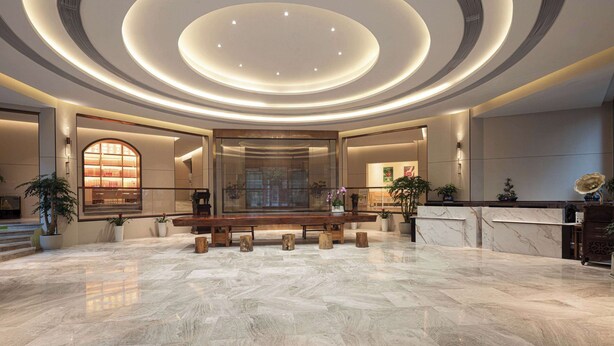 A spacious lobby with a marble floor, a reception desk, and a large window with a view of the outside. - Days Hotel BY Wyndham Hengyang Nanyue (Hengyang)